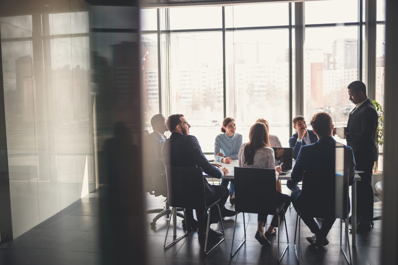 boardroom table with people sitting around